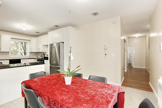 dining space with light wood-type flooring and sink