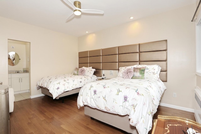 bedroom featuring hardwood / wood-style flooring, ceiling fan, sink, and ensuite bath