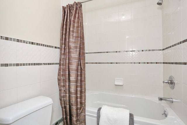 bathroom with tile walls, shower / tub combo, and toilet