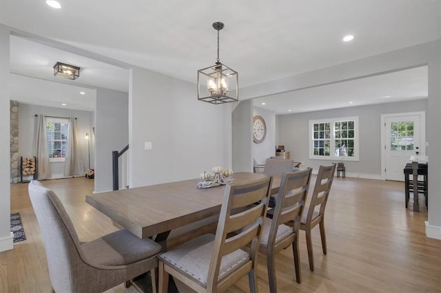 dining space featuring light wood-type flooring and a chandelier