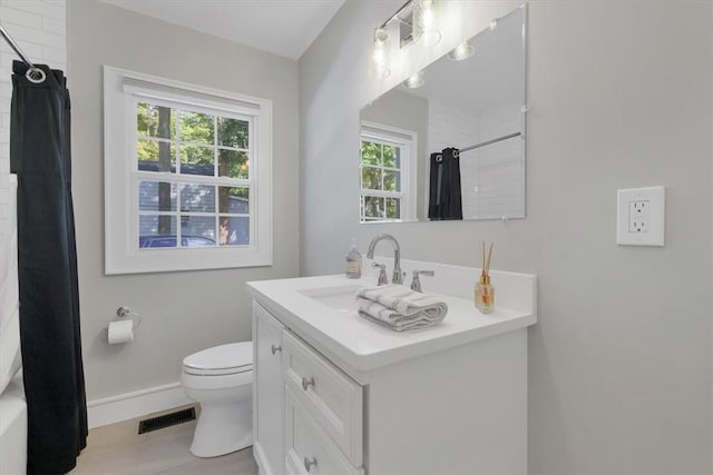 bathroom featuring curtained shower, plenty of natural light, vanity, and toilet