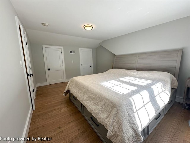 bedroom featuring hardwood / wood-style floors and vaulted ceiling