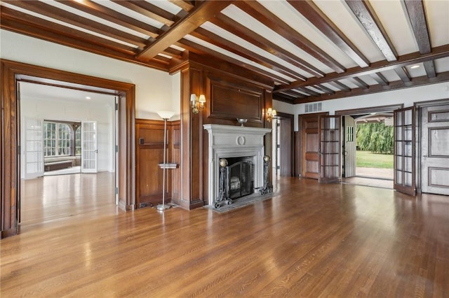 unfurnished living room with beamed ceiling and light hardwood / wood-style flooring