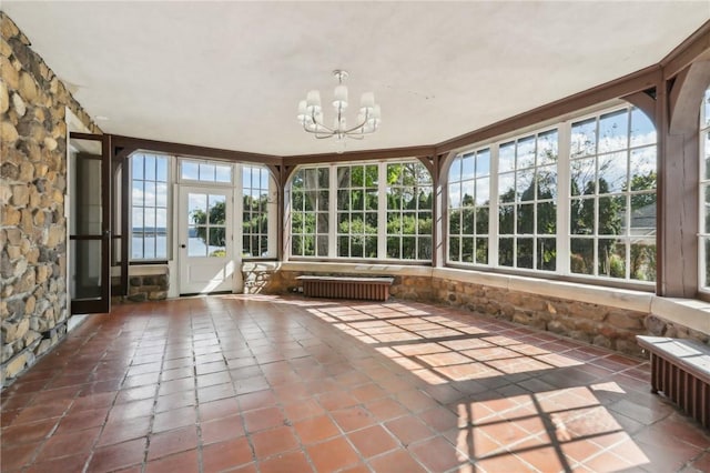 unfurnished sunroom featuring radiator heating unit and a notable chandelier