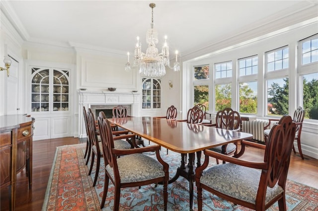 dining room with a fireplace, crown molding, dark wood-type flooring, and a wealth of natural light