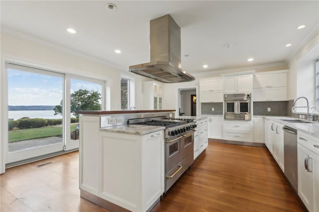 kitchen featuring island exhaust hood, stainless steel appliances, sink, a water view, and white cabinets