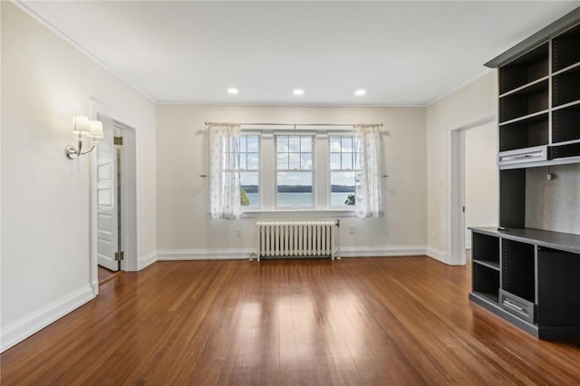 unfurnished living room featuring radiator heating unit, ornamental molding, and wood-type flooring