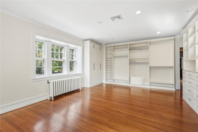 unfurnished bedroom featuring wood-type flooring, ornamental molding, and radiator