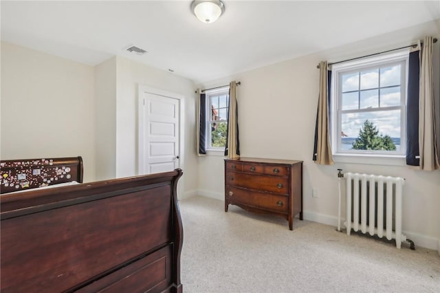 carpeted bedroom featuring radiator