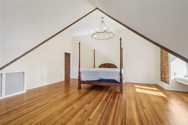 unfurnished bedroom featuring light hardwood / wood-style floors, vaulted ceiling, and an inviting chandelier