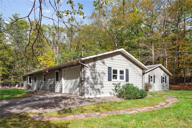 view of property exterior with a lawn, aphalt driveway, and an attached garage