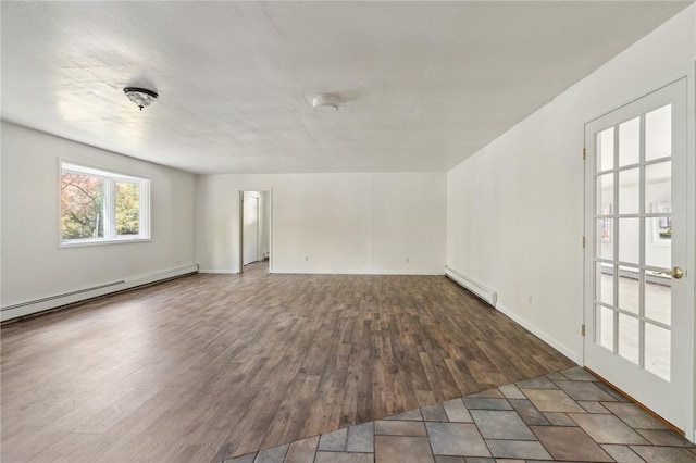 spare room featuring baseboards, wood finished floors, and a baseboard heating unit