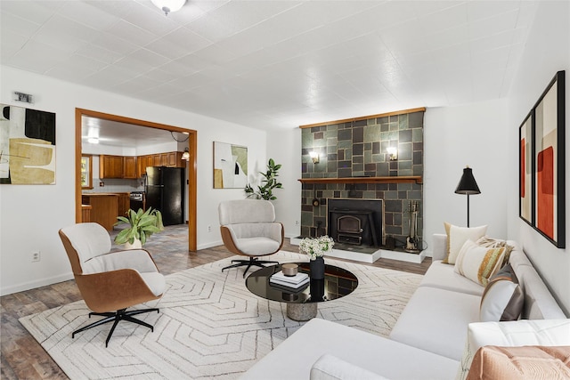 living area featuring baseboards, wood finished floors, and a wood stove