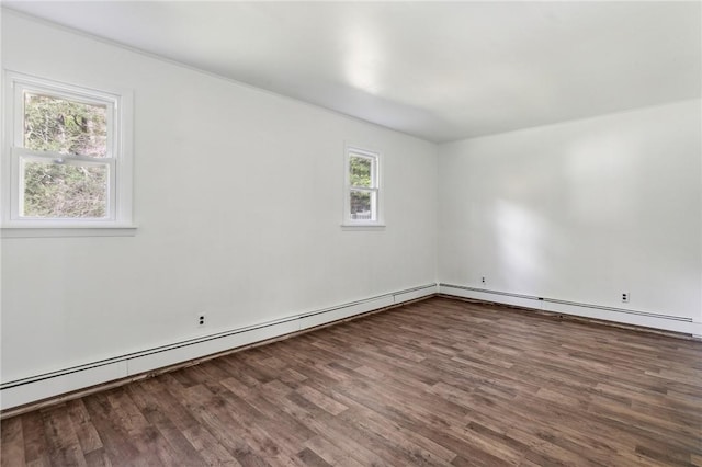 empty room featuring baseboard heating and wood finished floors