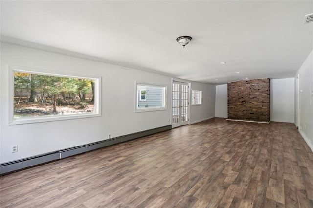 empty room with wood finished floors, visible vents, baseboards, and baseboard heating