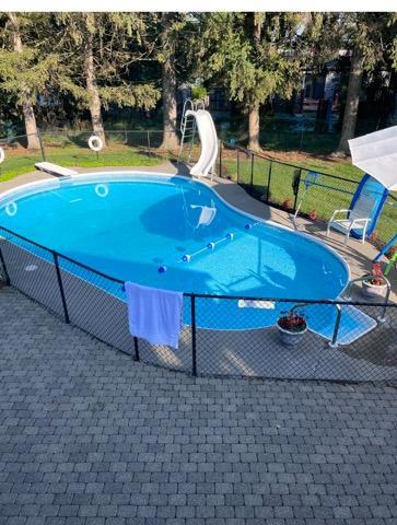 view of pool with a diving board, a water slide, and a patio