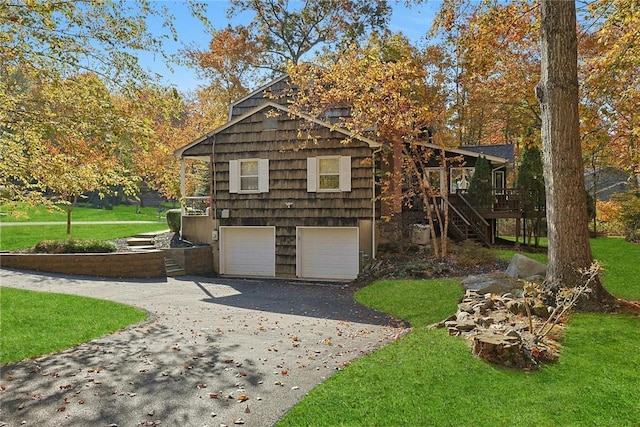 view of front of house featuring a garage, a front lawn, and a wooden deck