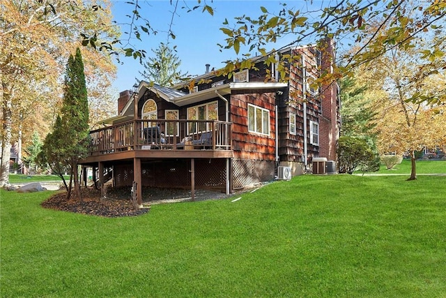 rear view of house with a deck and a lawn