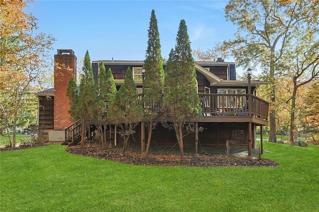 rear view of property featuring a lawn and a wooden deck