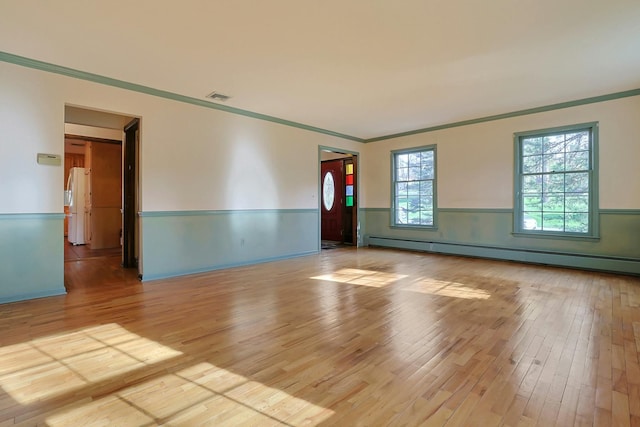 spare room featuring ornamental molding, light hardwood / wood-style flooring, and a baseboard radiator