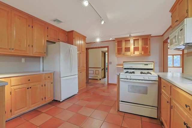 kitchen featuring light tile patterned floors, white appliances, and rail lighting