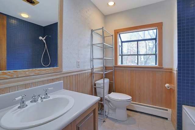 bathroom with tile patterned floors, a tile shower, vanity, a baseboard heating unit, and toilet