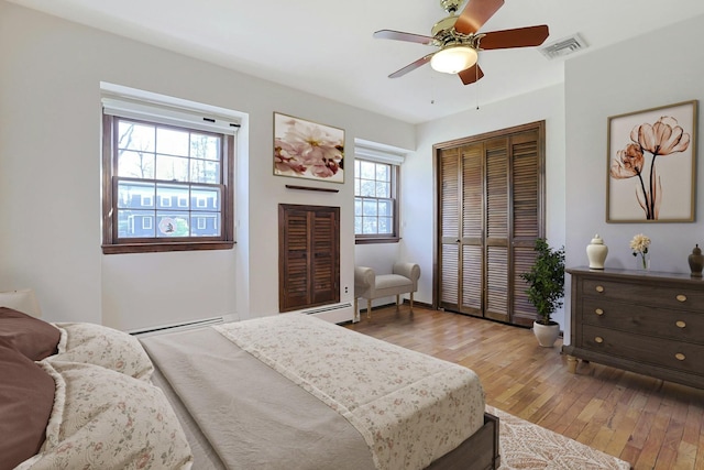 bedroom featuring multiple windows, ceiling fan, a closet, and light wood-type flooring