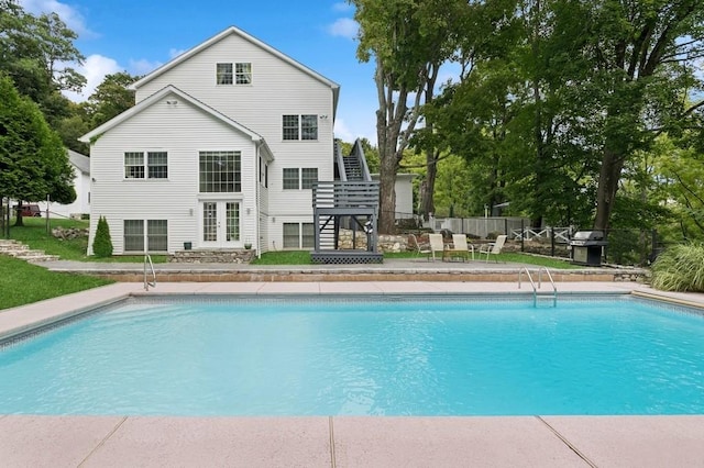 rear view of house with a fenced in pool