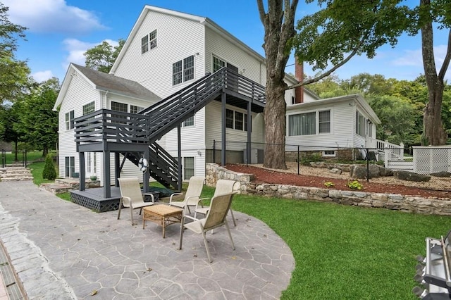 back of property with a patio area and a lawn