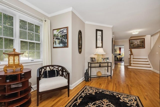 sitting room with wood-type flooring and crown molding