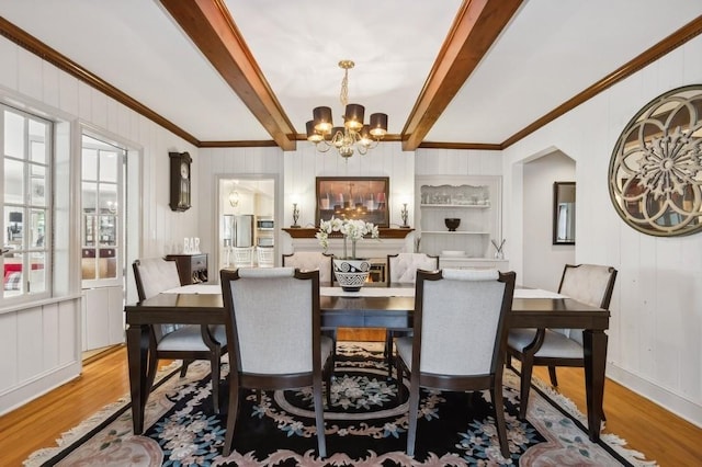 dining area with crown molding, beamed ceiling, a chandelier, and hardwood / wood-style flooring