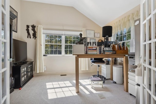 carpeted home office with french doors and vaulted ceiling