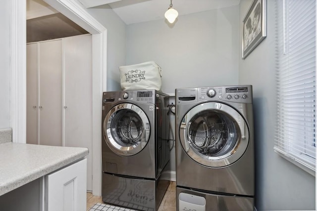 clothes washing area with light tile patterned flooring and independent washer and dryer