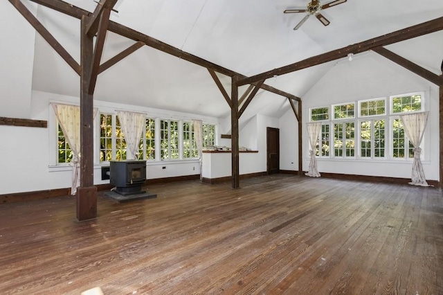 unfurnished living room with dark hardwood / wood-style flooring, high vaulted ceiling, a wood stove, and plenty of natural light