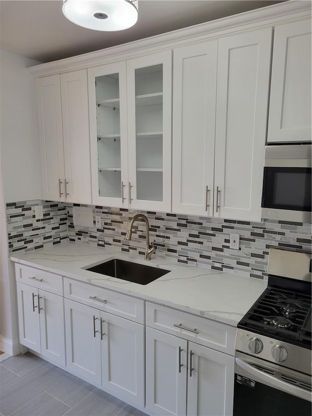 kitchen with white cabinets, light stone countertops, sink, and appliances with stainless steel finishes