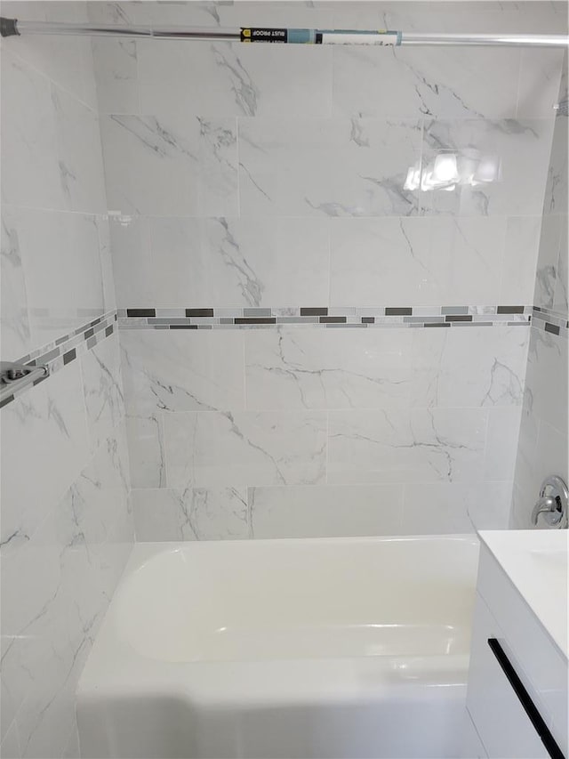 bathroom with vanity and tiled shower / bath combo