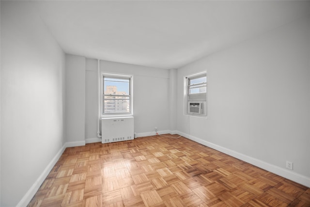 spare room with radiator, light parquet flooring, and cooling unit