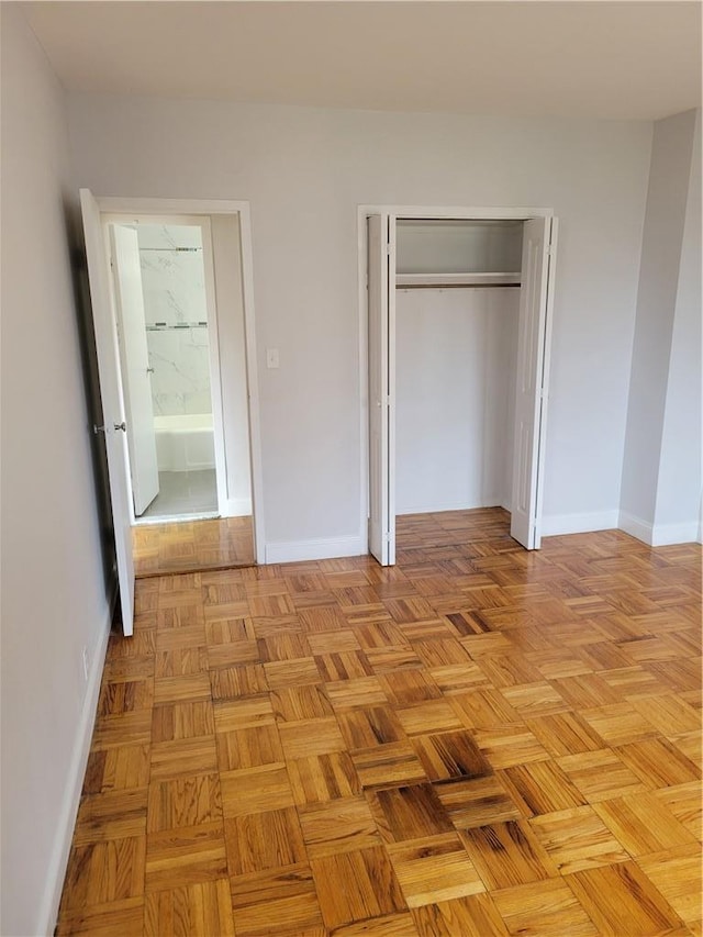 unfurnished bedroom with a closet and light parquet flooring