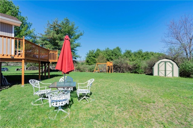 view of yard with a storage unit, a playground, and a wooden deck