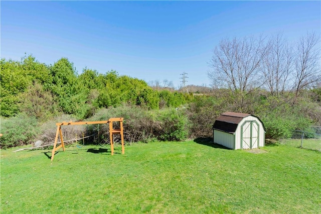 view of yard with a storage shed and a playground