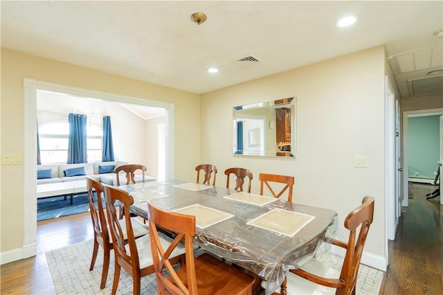 dining area with hardwood / wood-style floors and baseboard heating