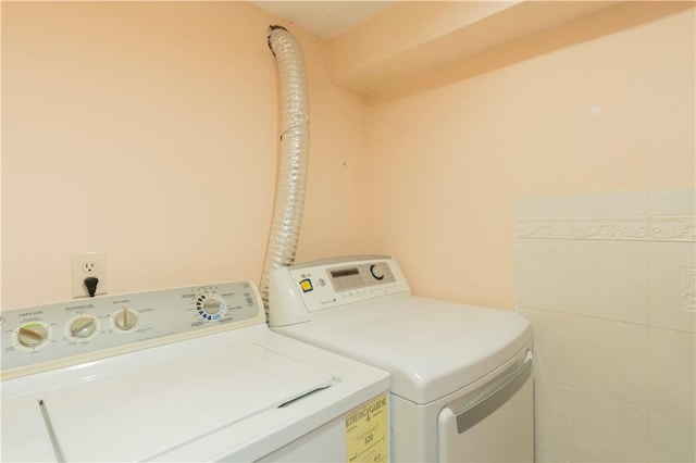 laundry room featuring tile walls and independent washer and dryer