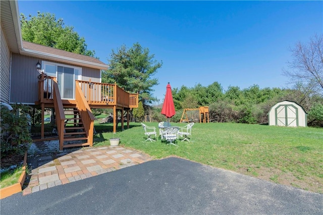 view of yard featuring a storage unit, a patio, and a deck