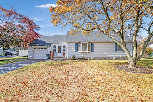 ranch-style house featuring a garage and a front yard