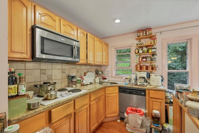 kitchen featuring a wealth of natural light, sink, appliances with stainless steel finishes, and light hardwood / wood-style flooring