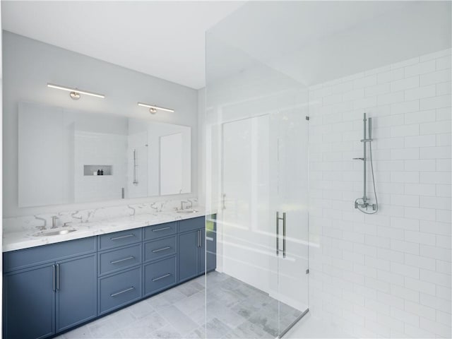 bathroom with vanity and a shower with door