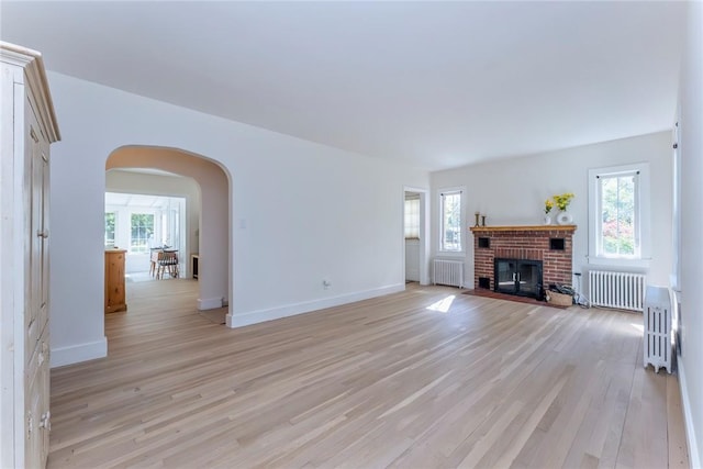 179 Grove St, Tillson, NY 12486 - unfurnished living room featuring radiator heating unit, arched walkways, and plenty of natural light