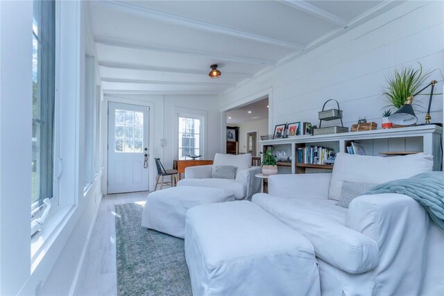 living room featuring wood-type flooring, vaulted ceiling with beams, and wooden walls