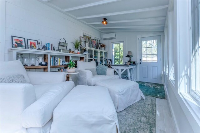 living room with a wall mounted air conditioner, lofted ceiling with beams, and hardwood / wood-style flooring