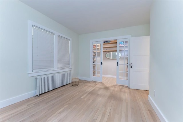 179 Grove St, Tillson, NY 12486 - spare room featuring radiator, french doors, light wood-style flooring, and baseboards